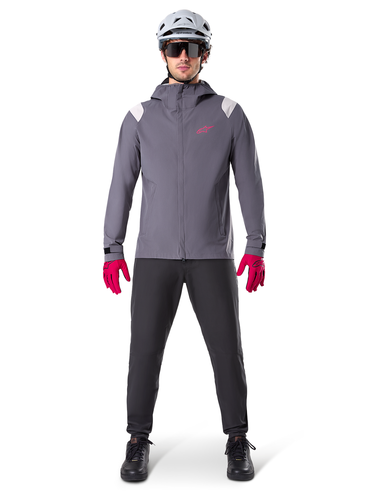 Alpinestars A-Dura Rain Jacket, Mountain Bike Jacket, Dark Titanium Gray with pink logo, worn with grey MTB helmet and bright pink gloves, protective 2.5-layer membrane design for wet weather cycling