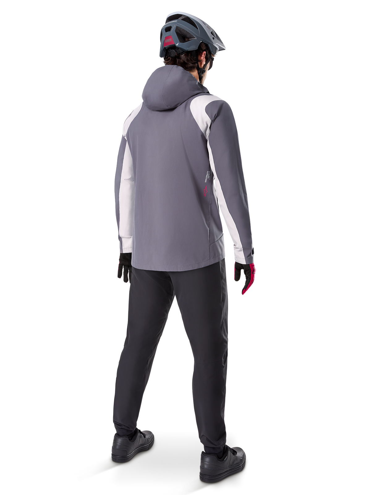 Alpinestars A-Dura Rain Jacket, Mountain Bike Jacket, Dark Titanium Gray with white panels, back view of rider wearing matching gray helmet and black pants, technical outdoor gear for wet weather