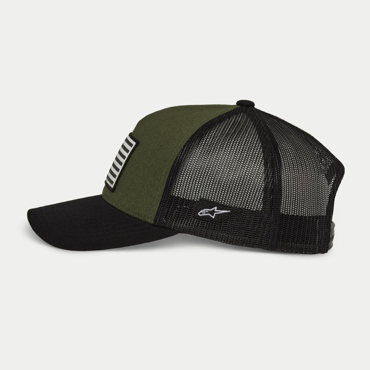 Alpinestars Flag Snapback-kasket, Military Black, set fra siden, olivengrønt frontpanel med sort buet skygge og sort mesh-bagside, hvidt broderet logo på siden, afslappet motorsportsinspireret hovedbeklædning