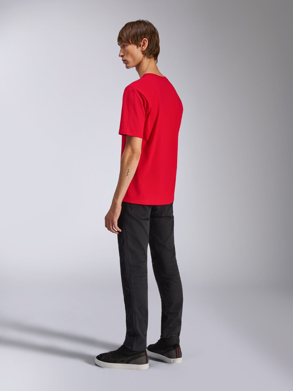 Alpinestars Ageless Shadow CSF Tee, kortærmet t-shirt, rød, set bagfra på model, båret med sorte bukser og sneakers, afslappet motorsport-inspireret streetwear