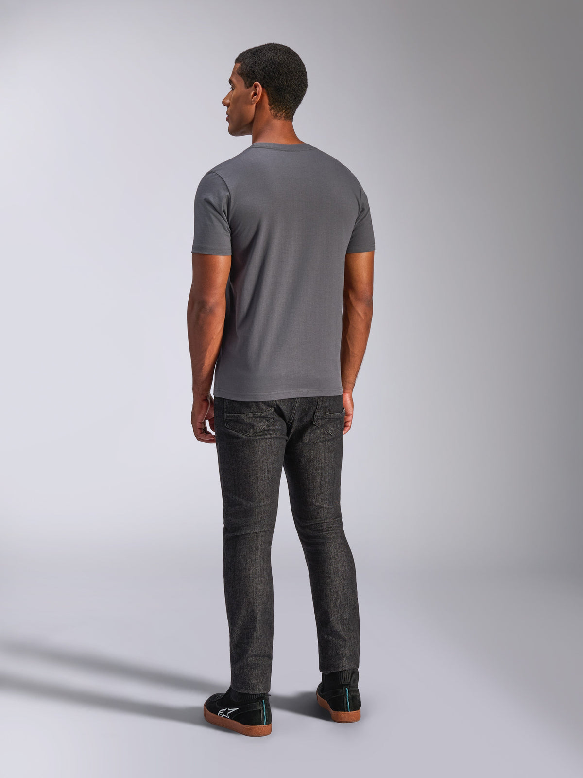 Alpinestars Always 2.0 CSF Tee, kortærmet t-shirt, koksgrå, set bagfra på model, parret med mørke denimbukser og sorte sneakers, afslappet motorsport-inspireret streetwear