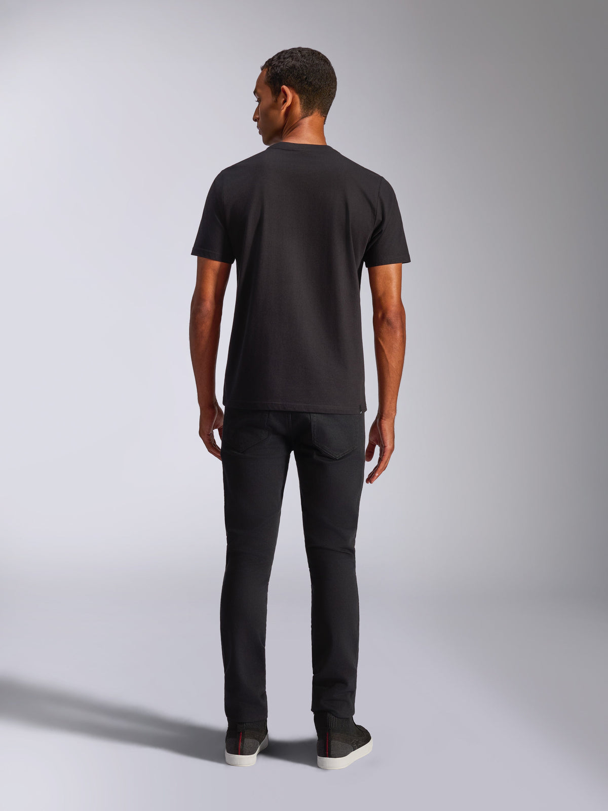 Alpinestars Blaze 2.0 CSF Tee, kortærmet t-shirt, sort, set bagfra, båret med sorte jeans, afslappet motorsport-inspireret streetwear