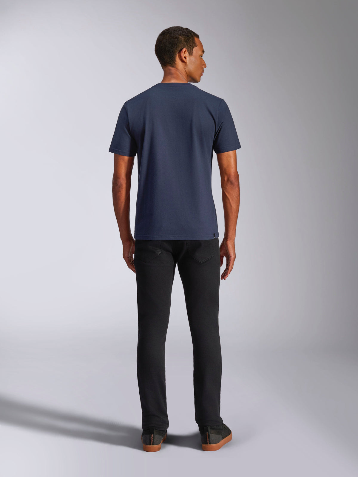 Alpinestars Ride 4.0 CSF Tee, kortærmet t-shirt, marineblå, set bagfra på model, kombineret med sorte jeans, afslappet motorsport-inspireret streetwear
