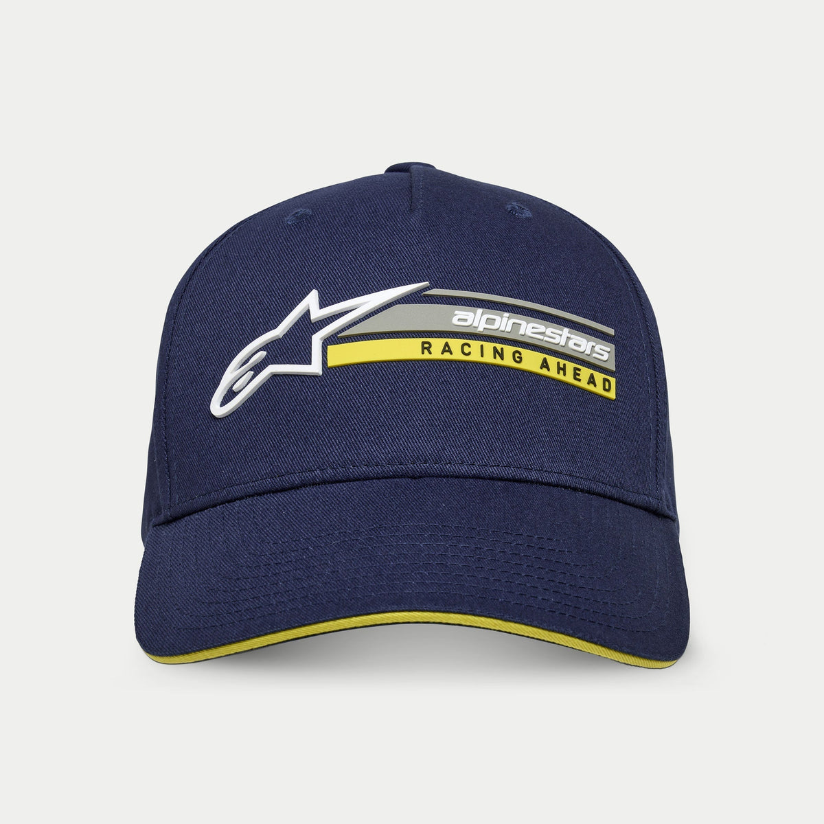 Alpinestars Par Hat, marineblå, struktureret snapback-kasket med kurvet skygge, med hvidt 3D Astars-logo og 'alpinestars RACING AHEAD'-grafik i grå og gul, gul sandwich-skygge detalje, afslappet motorsport streetwear