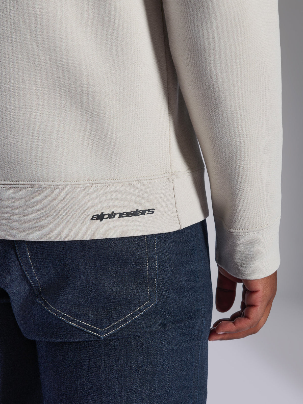 Alpinestars Positive Crew sweatshirt, råhvid, nærbillede af detalje med ribkant og manchet, lille sort Alpinestars-logo, afslappet motorsportsinspireret tøj