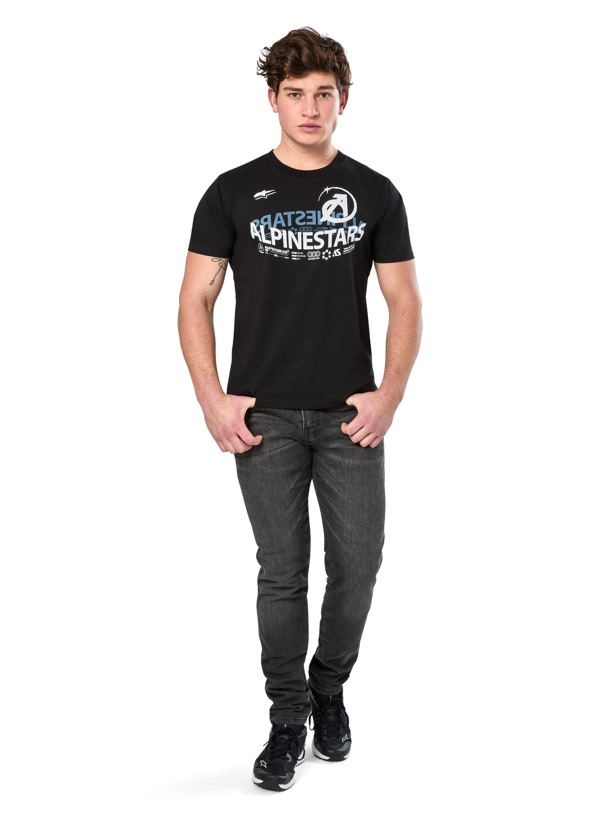 Alpinestars Semicircle CSF Tee, kortærmet t-shirt, sort, hvid og lyseblå buet grafik på brystet, vist på model med mørkegrå jeans og sorte sneakers, afslappet motorsport-streetwear