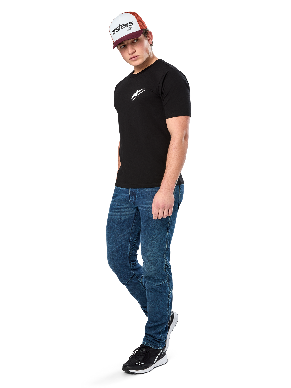 Alpinestars Formulate Csf Tee, kortærmet t-shirt, sort med hvidt Astars brystlogo, båret af en model med blå jeans, en bordeaux og hvid kasket og sorte sneakers, afslappet motorsport-inspireret streetwear