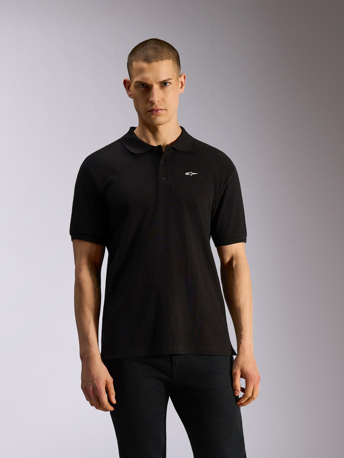 Alpinestars Endeavor Classic Polo, sort sportswear-polo, korte ærmer med lille hvidt Astars-logo på brystet, stolpelukning med tre knapper, klassisk piqué-strik, afslappet motorsport-inspireret stil