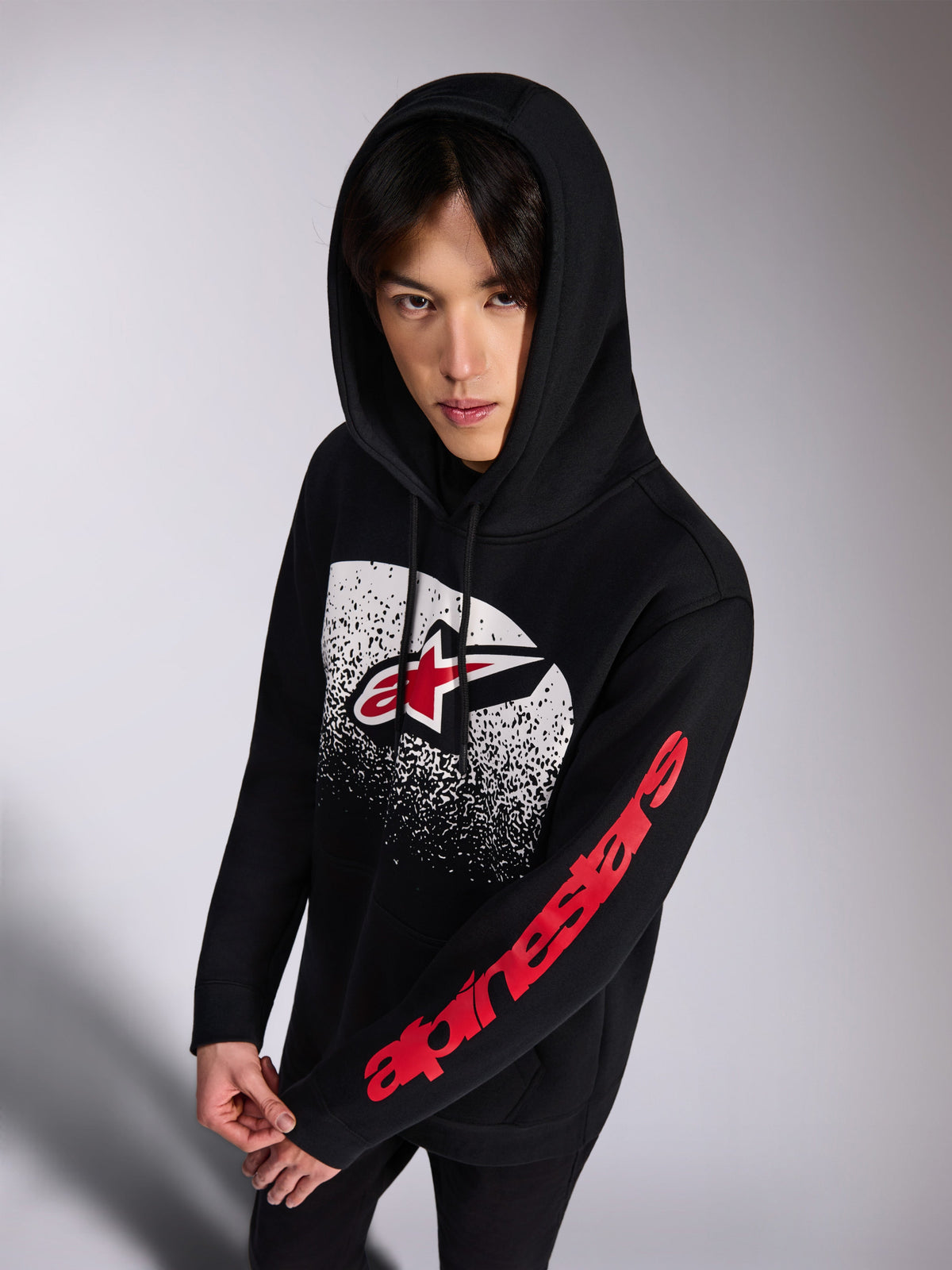 Alpinestars Obsessed hættetrøje, sort pullover-hættetrøje i fleece, rødt og hvidt Astars-logo på fronten med hvid MX-graduering i slidt look, rødt Alpinestars Word-logo på ærmet, hætte med snoretræk, afslappet motorsport-inspireret streetwear