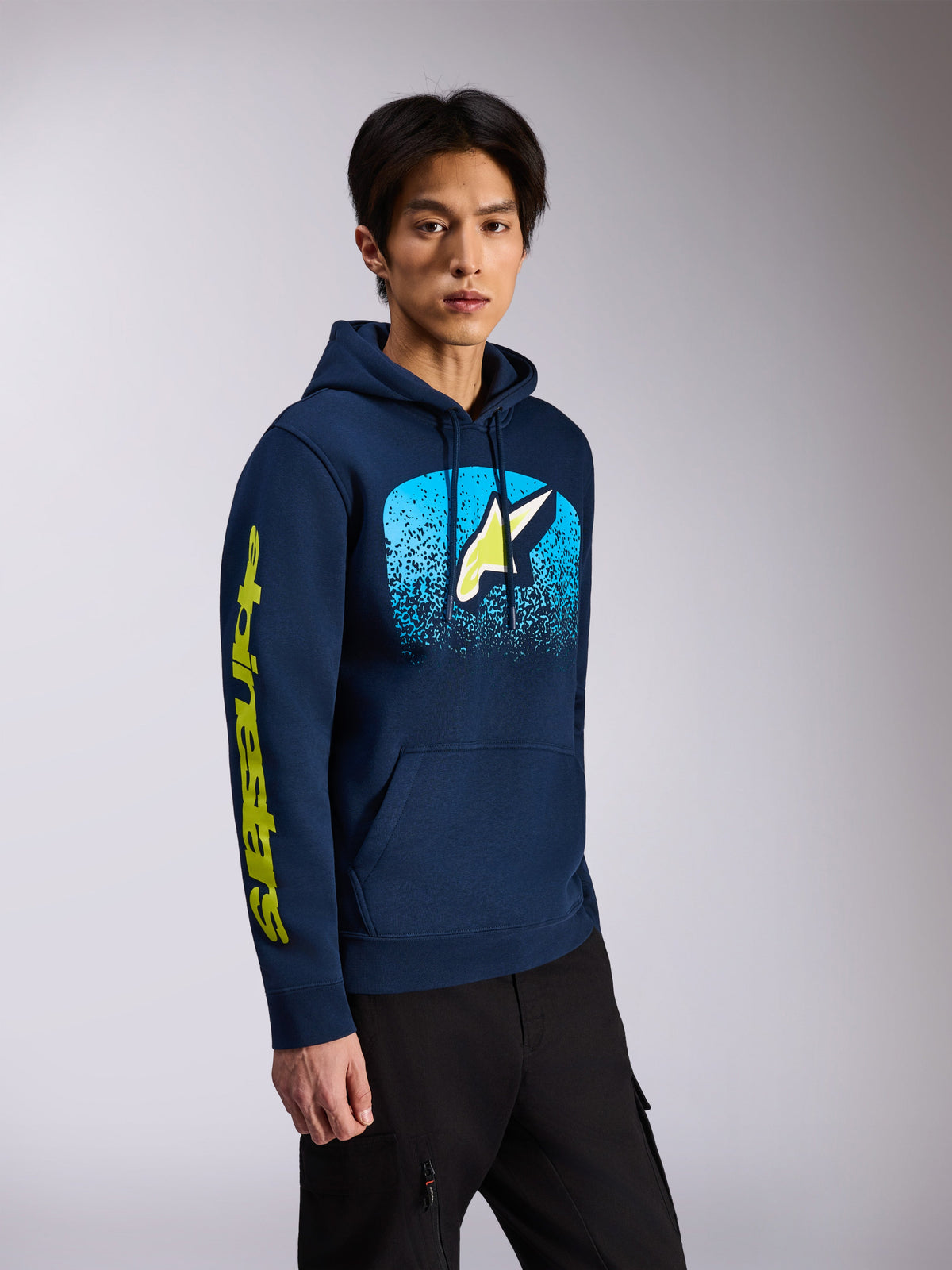 Alpinestars Obsessed Hættetrøje, marineblå, pullover fleece-hættetrøje, med Astars-logo på fronten med lyseblå MX-graduering og gult wordmark på ærmet, hætte med snoretræk, afslappet motorsport-streetwear