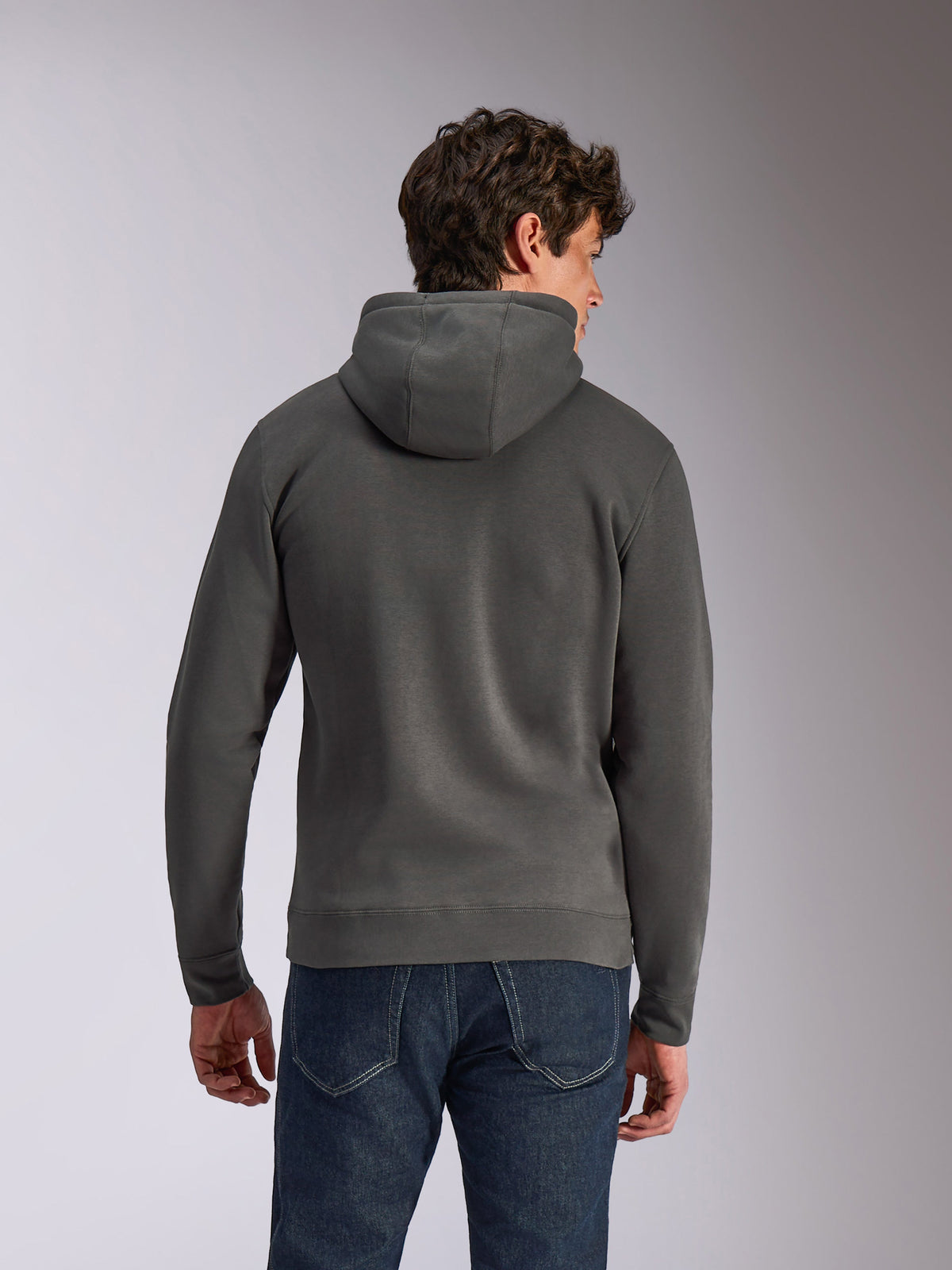 Alpinestars Ellipsoid hættetrøje, Gunmetal grå, afslappet sportstøj, set bagfra af mand iført hættetrøje i fleece, ribkanter og -søm, kombineret med blå jeans