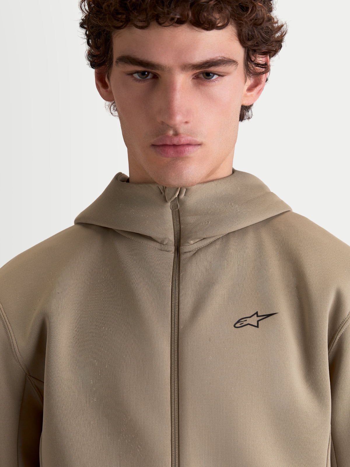 Alpinestars Cypher hættetrøje, herre sportswear fleecehættetrøje, beige, højhalset hætte med gennemgående lynlås, minimalistisk sort Alpinestars-logo på brystet, teknisk tri-blend materiale.