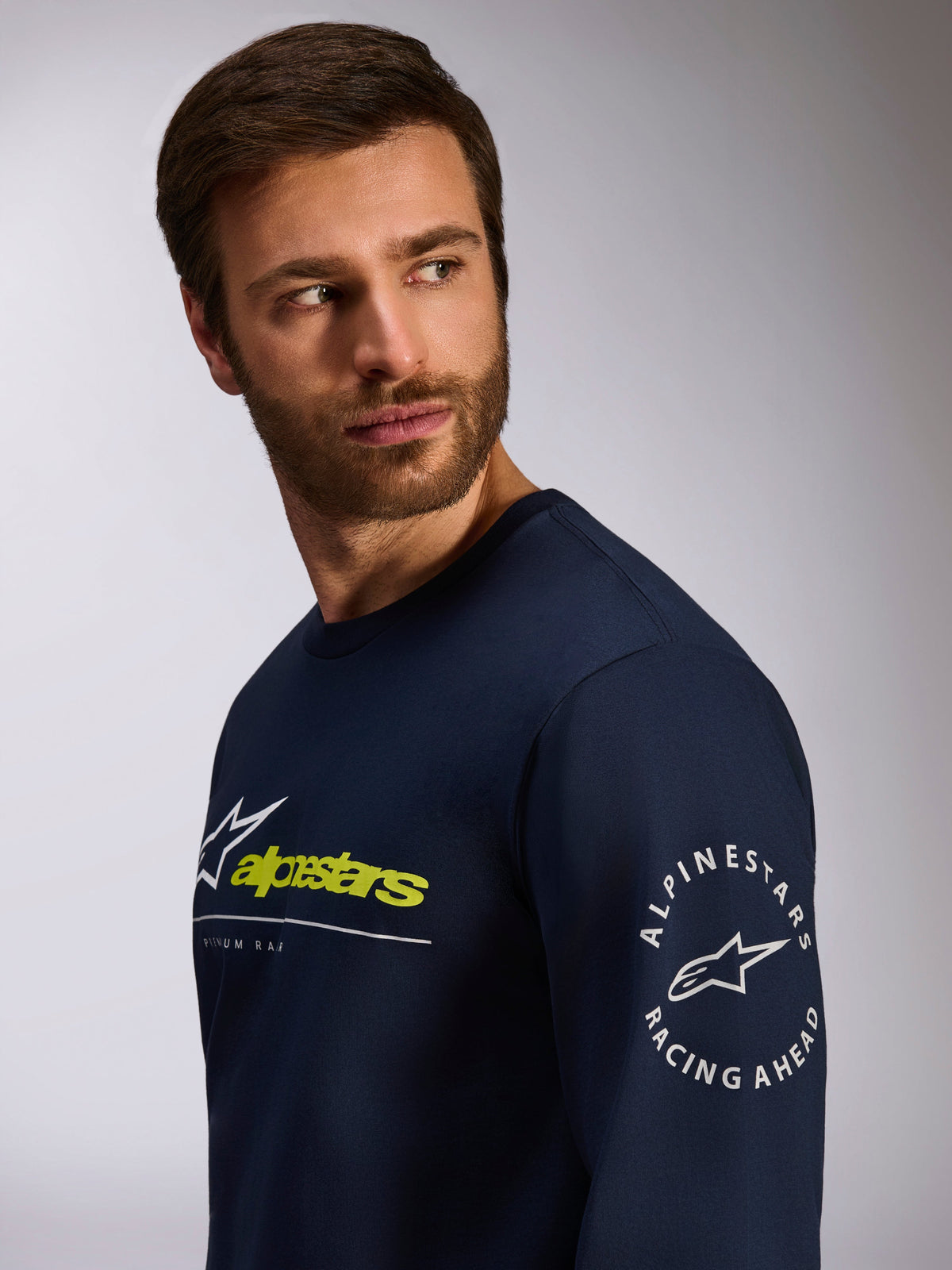 Alpinestars Mandatory CSF Tee, langærmet t-shirt, navyblå, med hvidt og limegrønt logo på fronten og cirkulært Alpinestars Racing Ahead-logo på ærmet, afslappet motorsport-streetwear