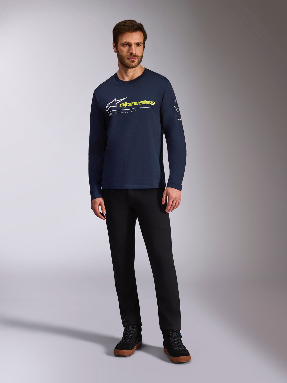Alpinestars Mandatory CSF Tee, langærmet t-shirt, mørkeblå, hvidt Astars-logo med neongult ordlogo, bæres af en model med sorte bukser og sorte sneakers, afslappet motorsport-streetwear