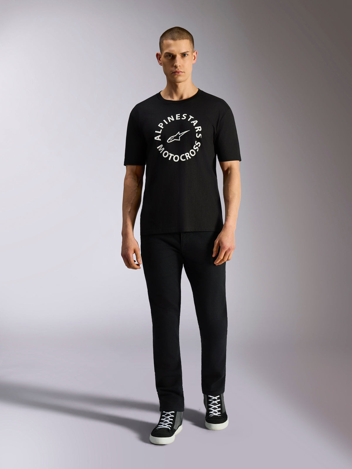 Alpinestars MX CSF Tee, kortærmet t-shirt, sort, hvid cirkulær Alpinestars Motocross-grafik, bæres af model med sorte bukser og sneakers, afslappet motorsport streetwear