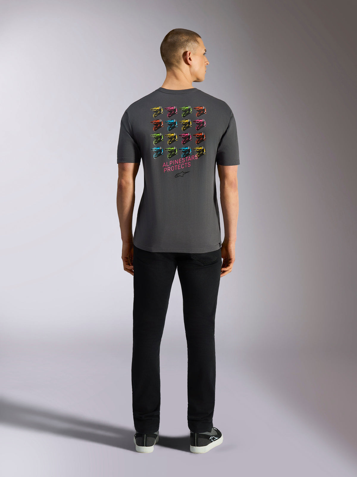 Alpinestars Pop Helmet CSF Tee, kortærmet t-shirt, koksgrå, med et gitter af flerfarvet M10-hjelmgrafik på ryggen og 'ALPINESTARS PROTECTS'-tekst, afslappet motorsport-streetwear