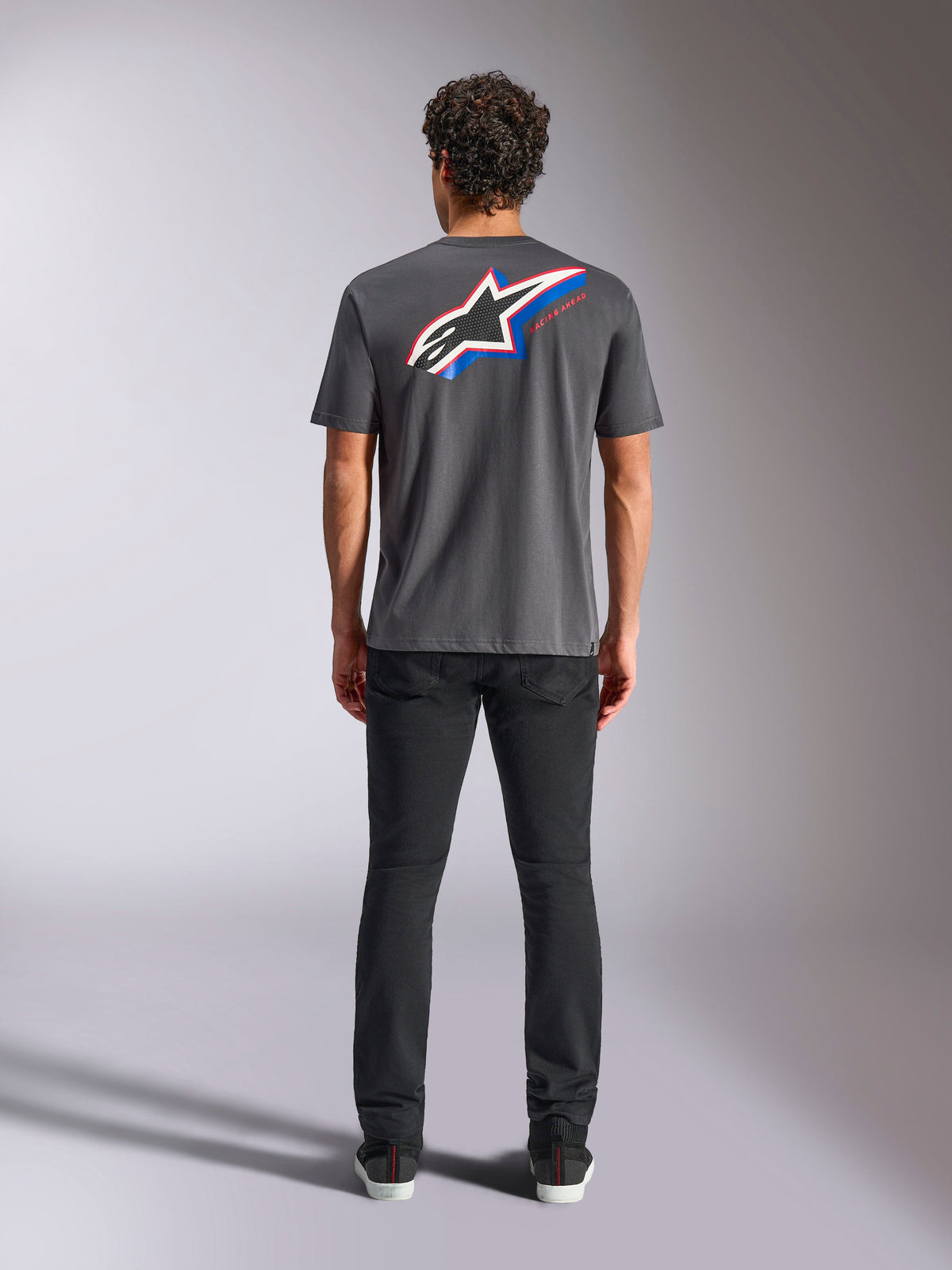 Alpinestars Angler CSF Tee, Short Sleeve T-Shirt, Charcoal, Large Multi-color Astars Logo on back with red and blue accents, rear view on model, casual motorsport streetwear