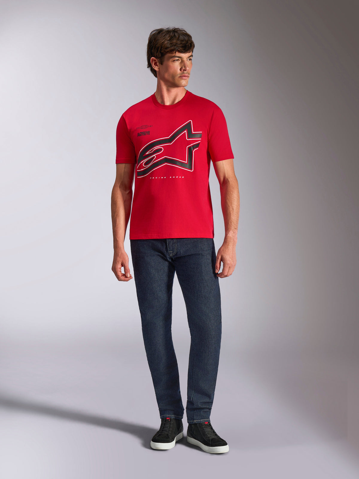 Alpinestars Authority CSF Tee, kortærmet t-shirt, rød, stort sort beskåret Astars-logo med hvid kontur, båret med mørkeblå jeans og sorte sneakers, afslappet motorsport-inspireret streetwear