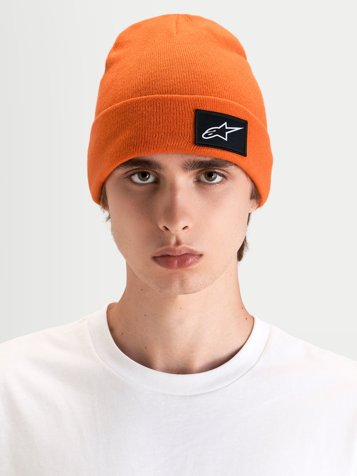 Alpinestars Augment Cuff Beanie, orange sportswear-beanie med vævet Astars-logo, båret af mandlig model i en dyb pasform-silhuet