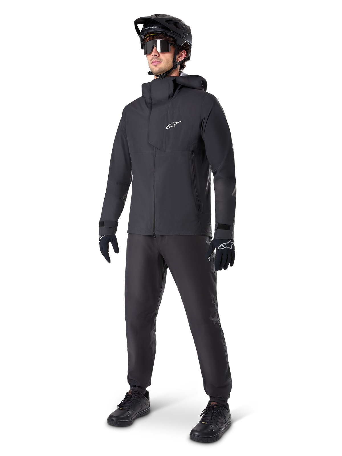 Alpinestars A-Dura Elite vandtæt jakke i sort, båret af en mandlig rytter med matchende sorte MTB-bukser, handsker og hjelm. Jakken har et teknisk vandtæt design med et hvidt Astars-logo på brystet og en høj beskyttende krave.