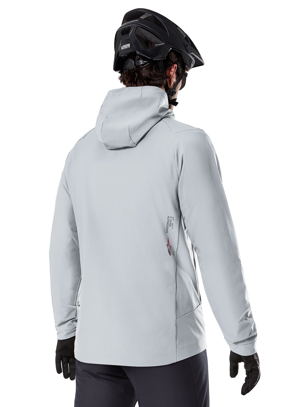 Alpinestars A-Dura Thermal Jacket, Titanium Gray, rygbillede af en rytter iført den isolerede jakke med hætte, kombineret med en sort MTB-hjelm og sorte handsker, med et lille Alpinestars-logo nederst på ryggen, designet til mountainbiking i koldt vejr.