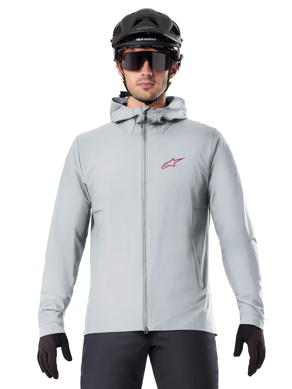 Alpinestars A-Dura Thermal Jacket i Titanium, lysegrå cykeljakke med hætte, rødt stjernelogo på brystet, båret af en rytter med sort MTB-hjelm, solbriller og handsker, isoleret udstyr til mountainbiking