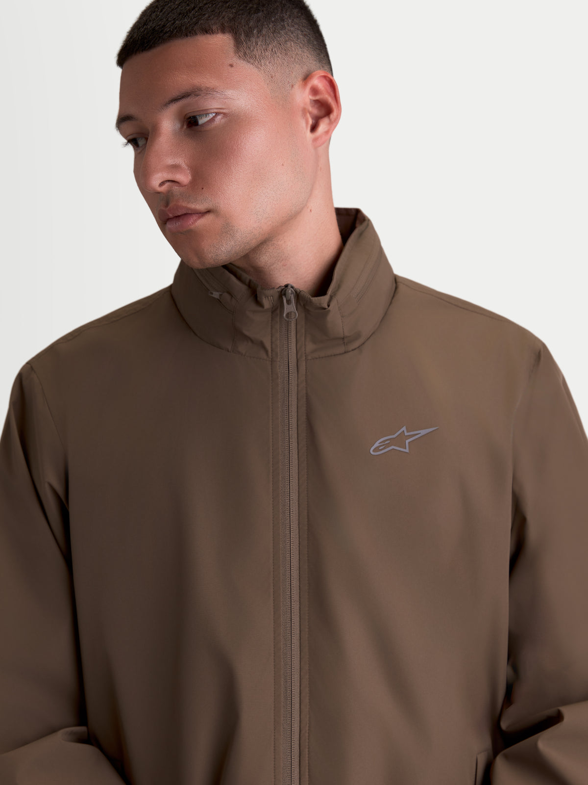 Alpinestars Overhaul Racer jakke, letvægts sportswear-jakke til herrer, brun, motorsportsinspireret design med høj krave, skjult hætterum og lille HD-printet Astars-logo på brystet.