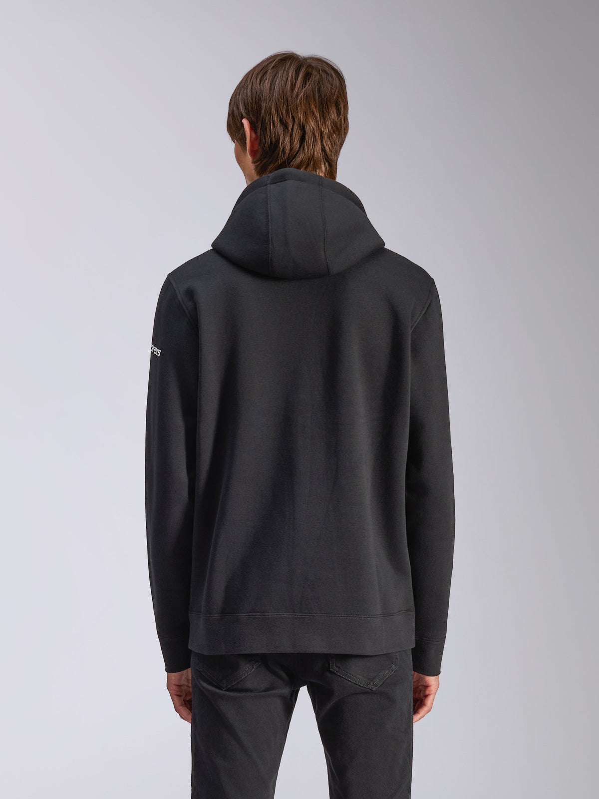Alpinestars Frontal hættetrøje, sort, set bagfra, afslappet pullover sweatshirt med selvforet hætte, ribkant og hvidt logo på ærmet, motorsport-inspireret streetwear