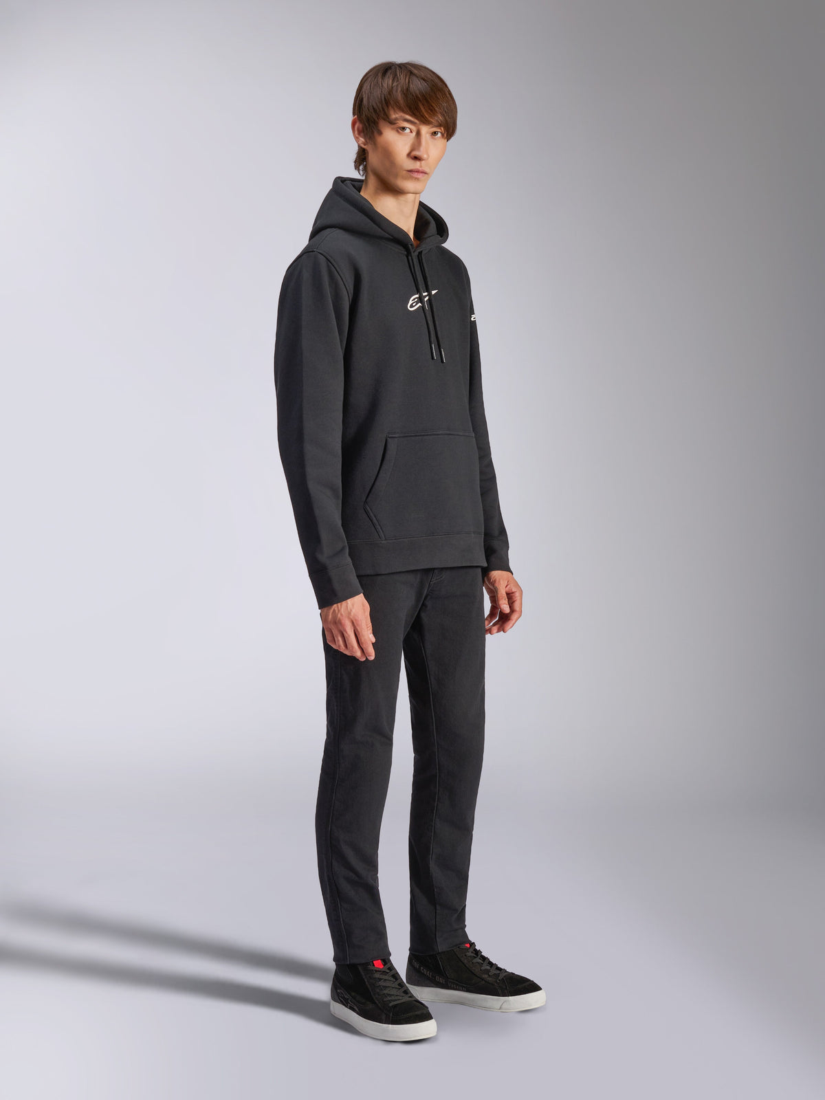 Alpinestars Frontal hættetrøje, sort, pullover fleece-hættetrøje med hvidt HD-logo på brystet og ordmærke-logoer på ærmerne, kængurulomme, stylet med sorte bukser og sneakers, afslappet motorsport-inspireret streetwear