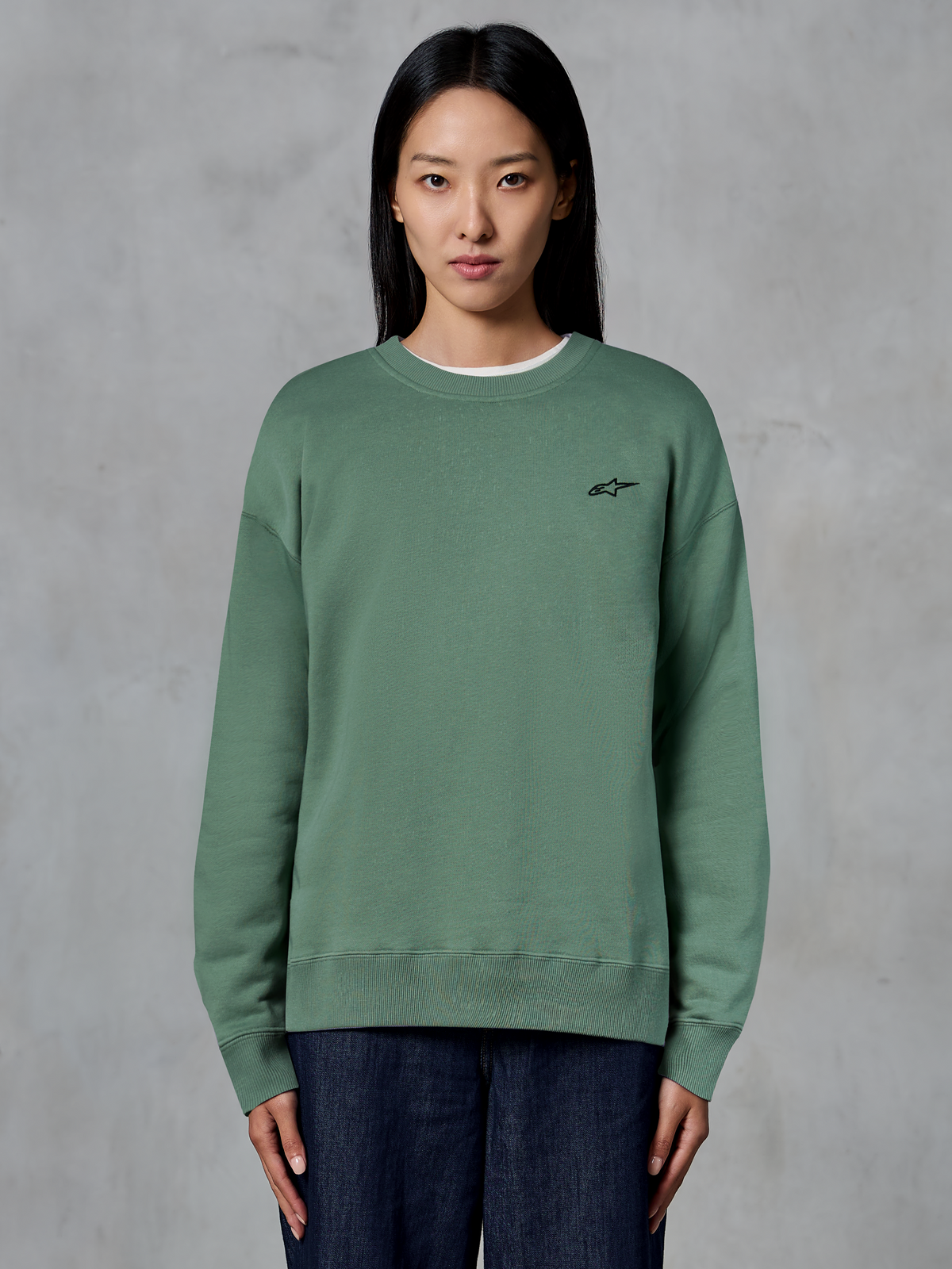 Alpinestars Essentials Ageless Crew, crewneck sweatshirt, kaktusgrøn, bæres af en model, lille sort logo på brystet, ribstrikket krave, manchetter og kant, afslappet motorsport streetwear