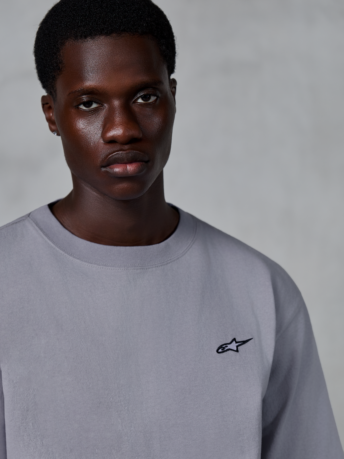 Alpinestars Essentials Ageless SS Tee, kortærmet t-shirt, sølvfarvet, med et lille sort stjerne-logo på brystet, båret af model, afslappet lifestyle streetwear