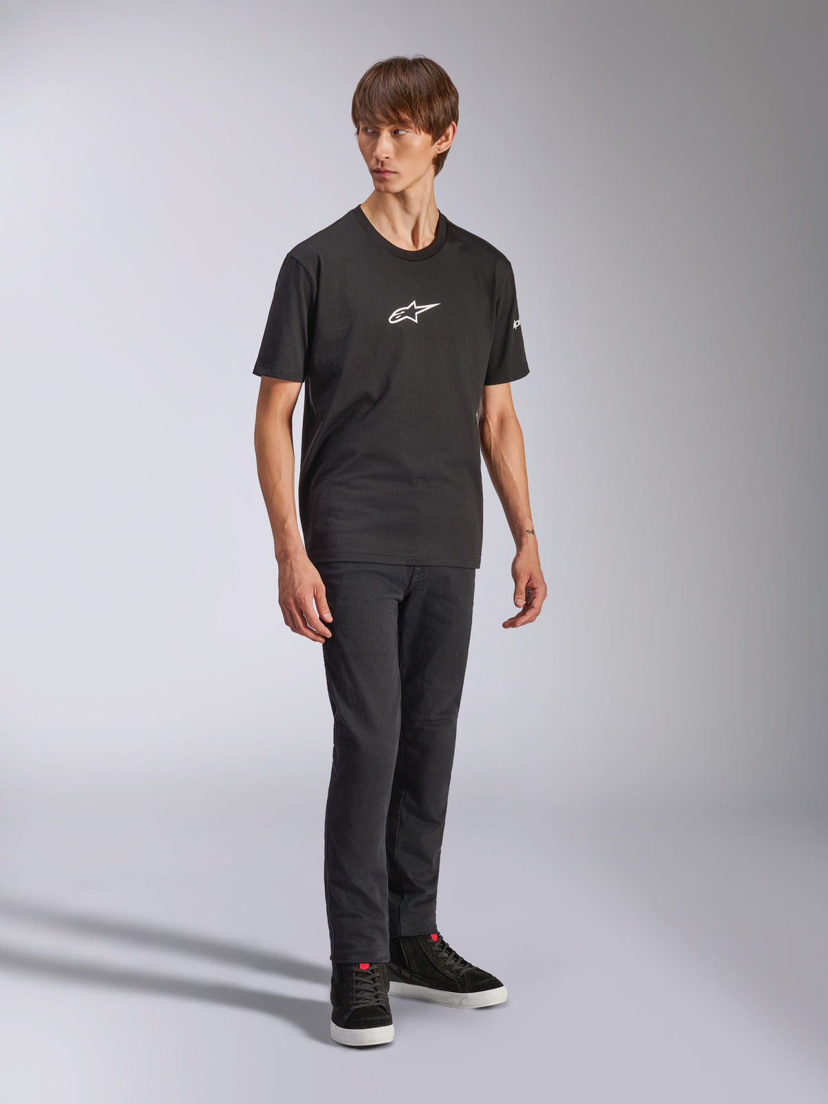 Alpinestars Frontal CSF Tee, kortærmet t-shirt, sort, hvidt Astars-logo på brystet, båret af en model med mørke jeans og sorte sneakers, casual performance streetwear