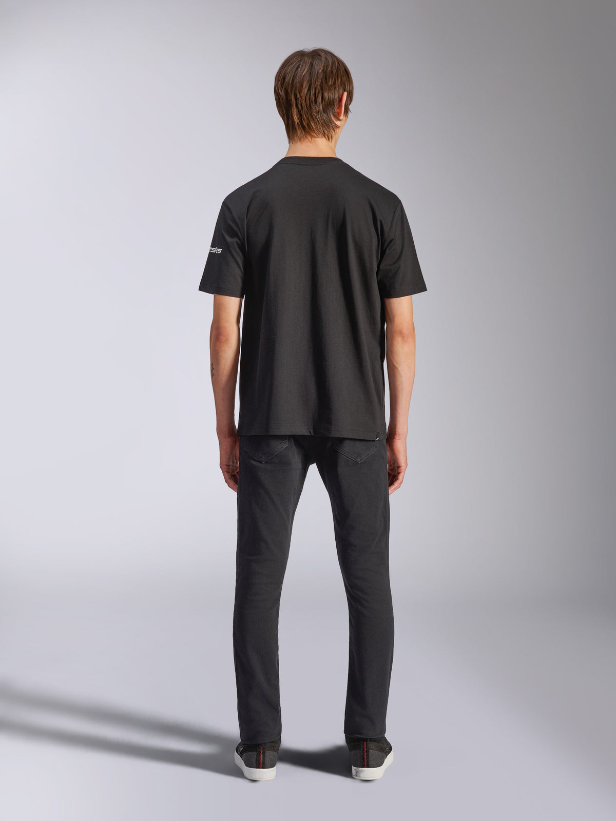Alpinestars Frontal CSF Tee, kortærmet T-shirt, sort, set bagfra på model i sorte jeans, casual performance streetwear med lille hvid logodetalje på ærmet