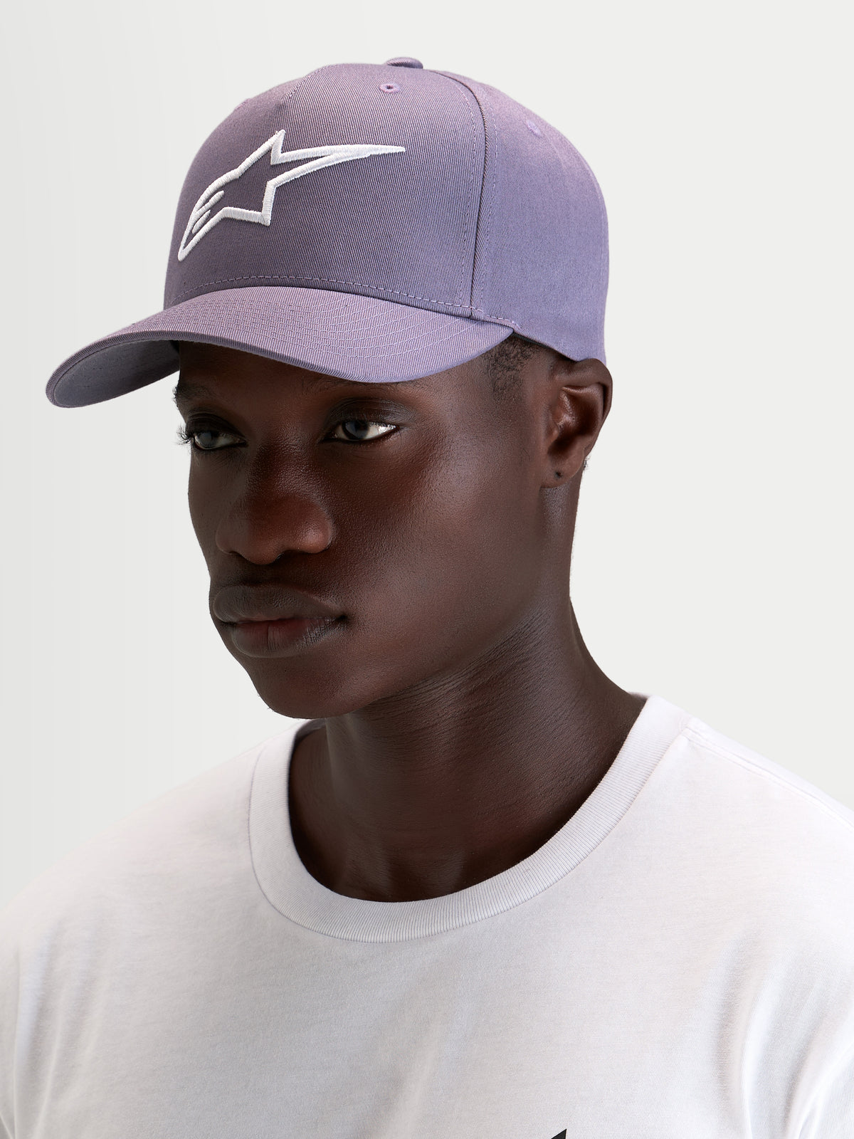 Alpinestars Ageless Snapback kasket, lilla og hvid sportswear-kasket med buet skygge og struktureret krone, båret af mandlig model