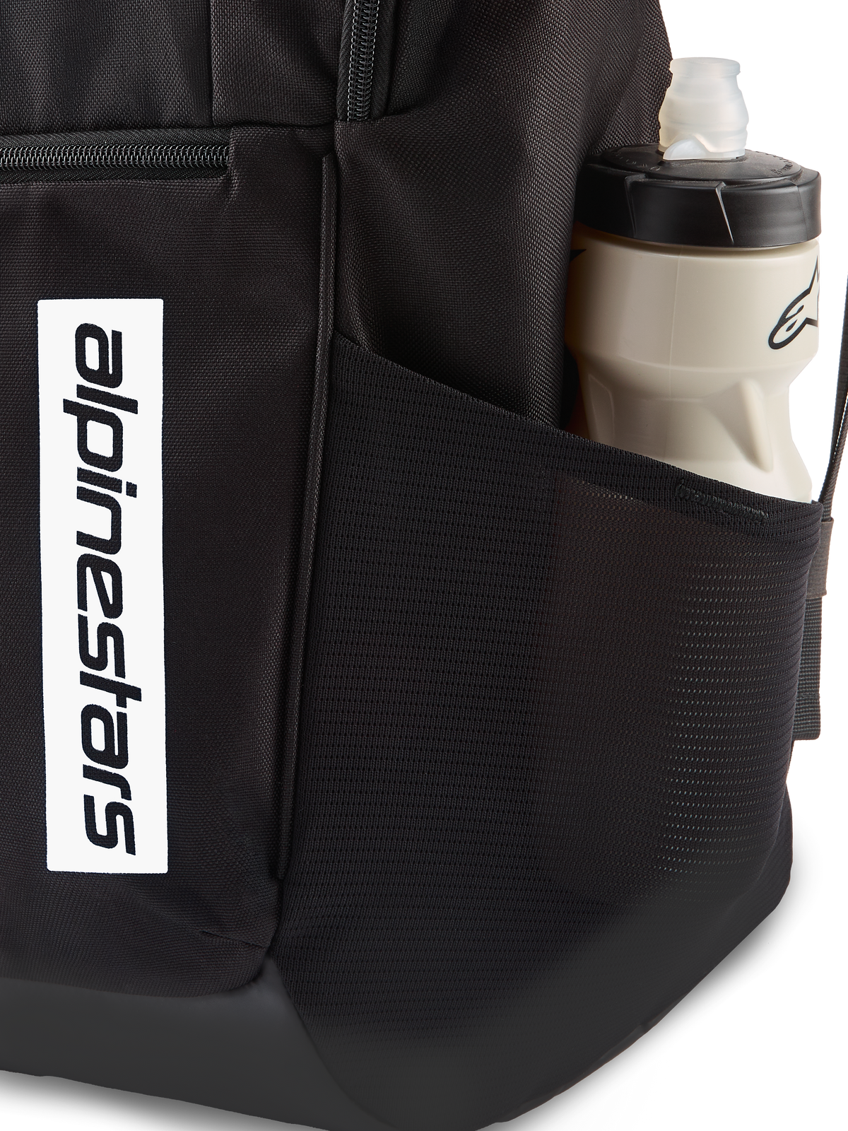 Alpinestars Defcon V3 Rygsæk, sort hverdagsrygsæk, nærbillede af sidelomme i mesh med vandflaske, lodret hvidt logo-branding på forsiden, holdbart 600D polyestermateriale