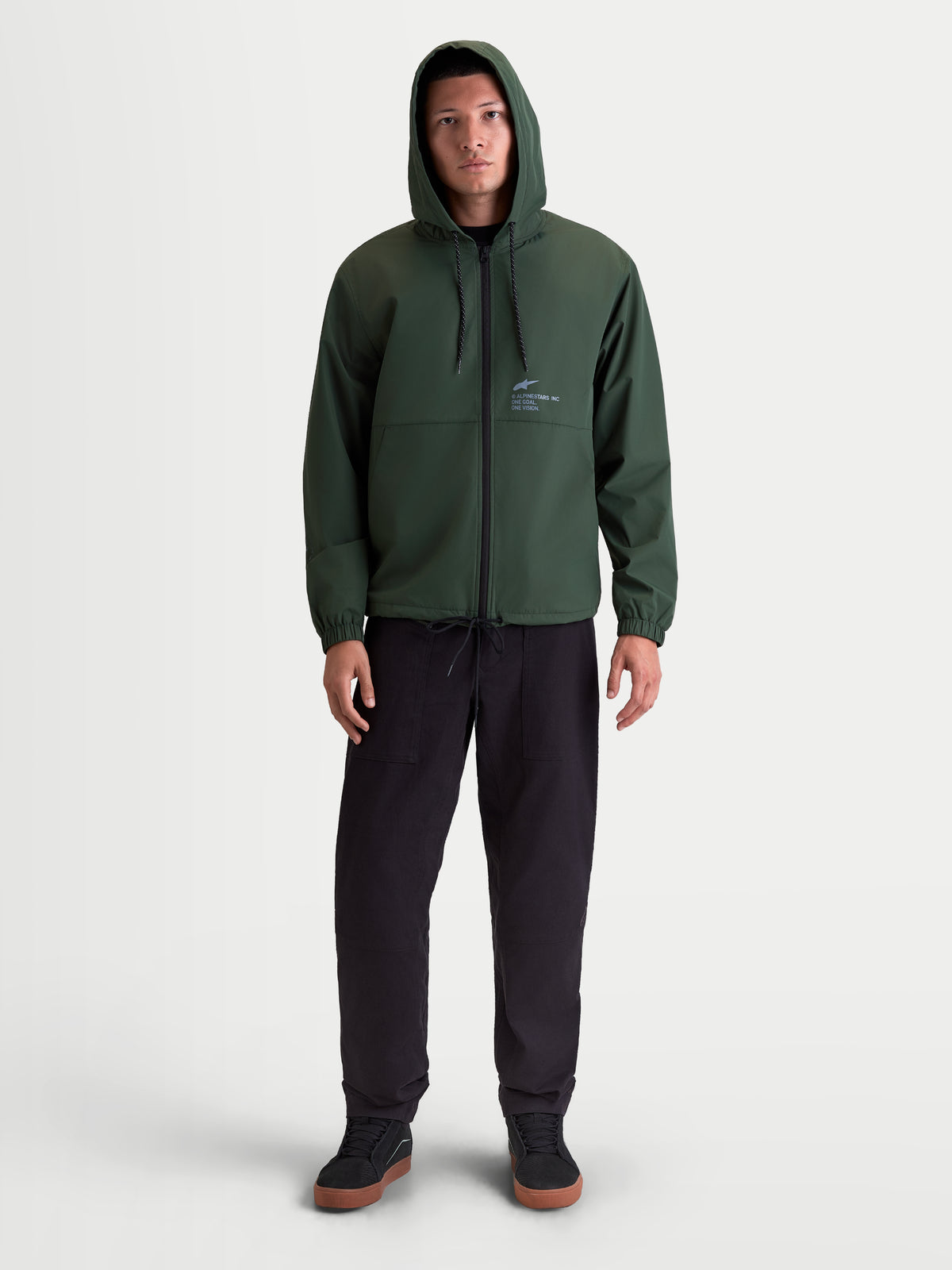 Alpinestars Speeder Resolve windbreaker, let sportswear-windbreakerjakke i grøn, 100% polyester, med justerbar hætte, omvendt spiral-lynlås og Alpinestars-logo på brystet, set forfra på model.