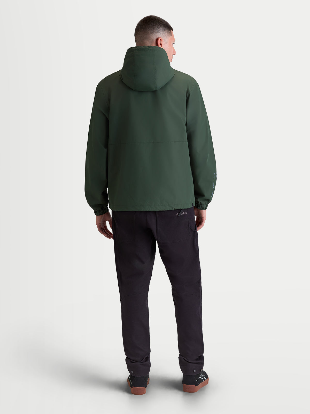 Alpinestars Speeder Resolve windbreaker, letvægts herre-sportswindbreaker med hætte i grøn, vindtæt tekstildesign, set bagfra med fokus på hætte og elastiske manchetter.