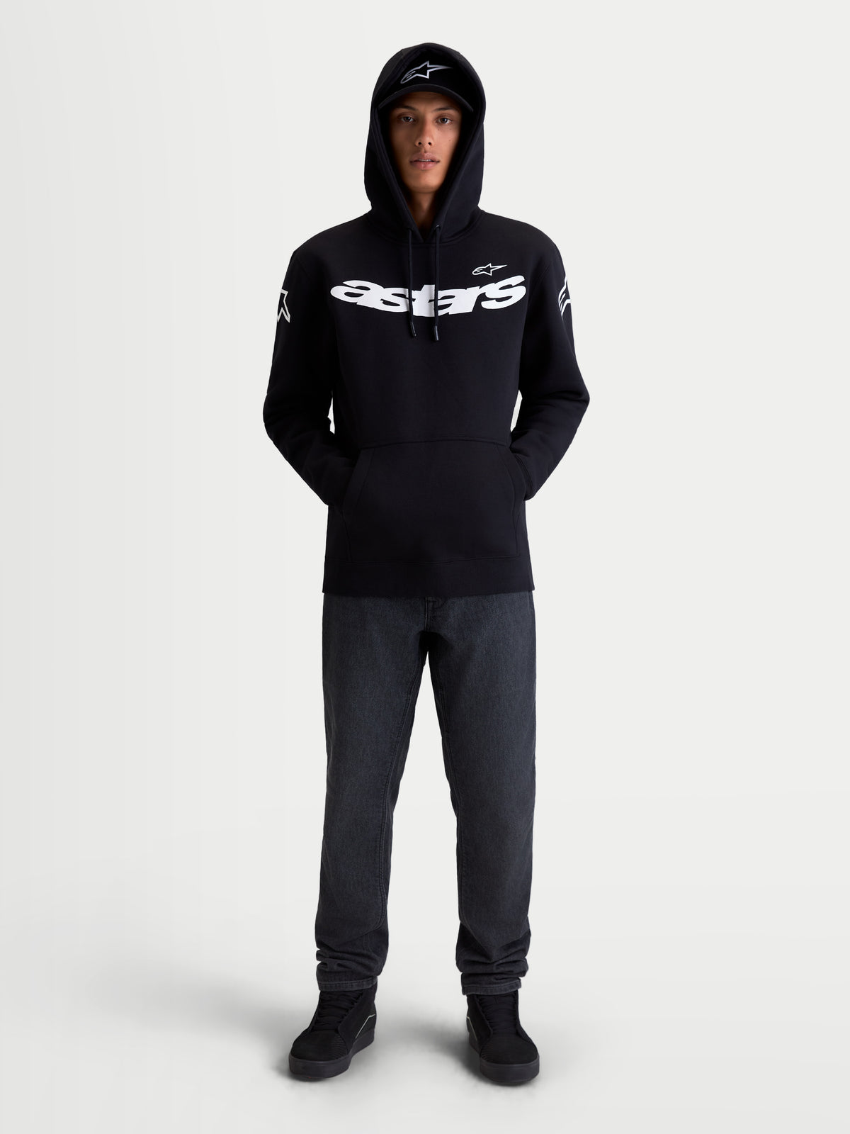 Alpinestars Velocifier hættetrøje, sportshættetrøje i fleece til hverdagsbrug, unisex, sort og hvid, fremstillet af bomuld og genanvendt polyester, med markant Astars-branding på brystet og logoer på skuldrene, vist på model set forfra.