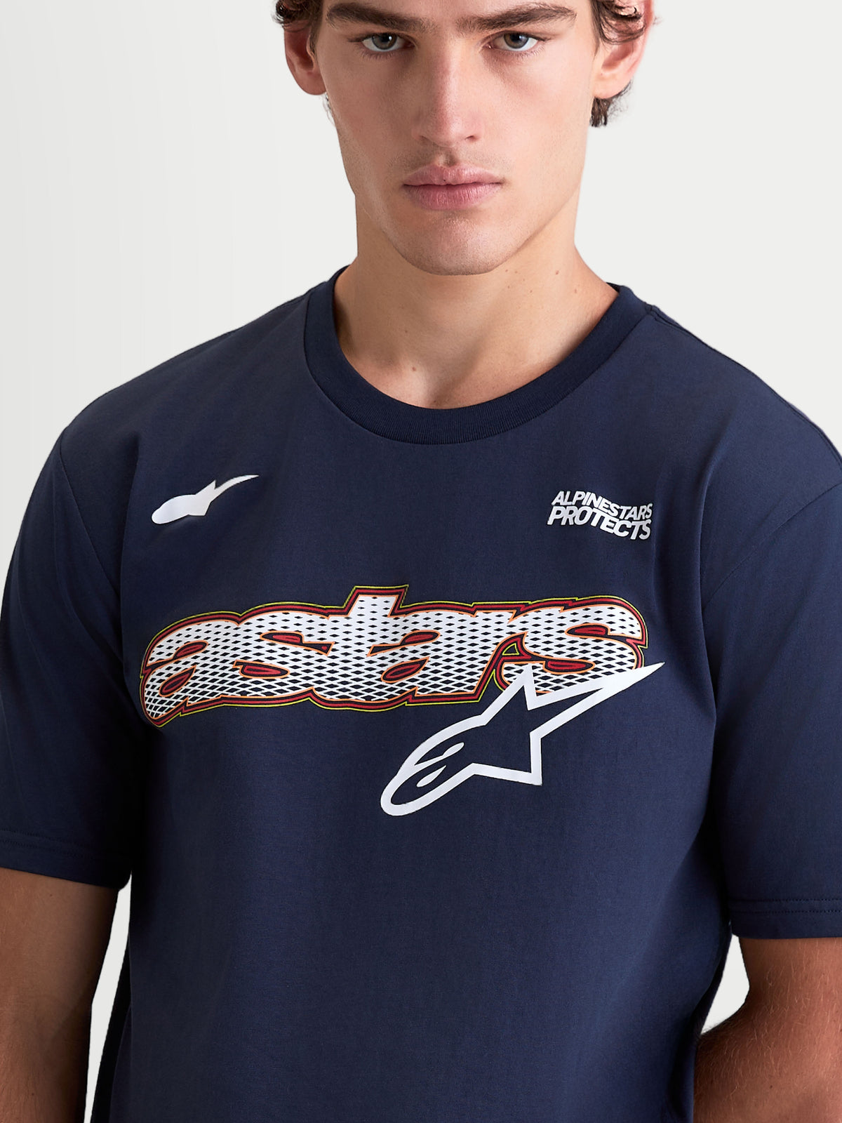 Alpinestars Cypress CSF T-shirt, kortærmet sportswear-trøje til herrer, navyblå og hvid, med Astars-grafik med meshfyld og logo på brystet, Alpinestars Protects-tekst, bomulds-polyesterblanding, nærbillede på model.