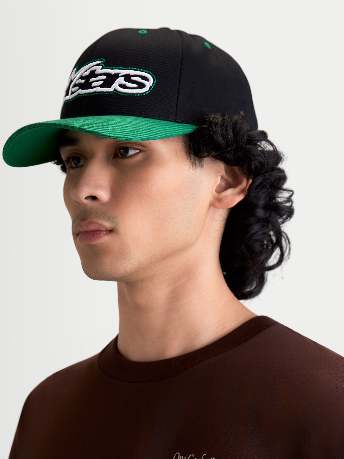 Alpinestars Retro Snapback Kasket, herrekasket til hverdagsbrug i sort og grøn, buet skygge og struktureret krone, broderet Astars-logo med grønne løbesting, motorsport-inspireret sportswear i bomuldstwill.