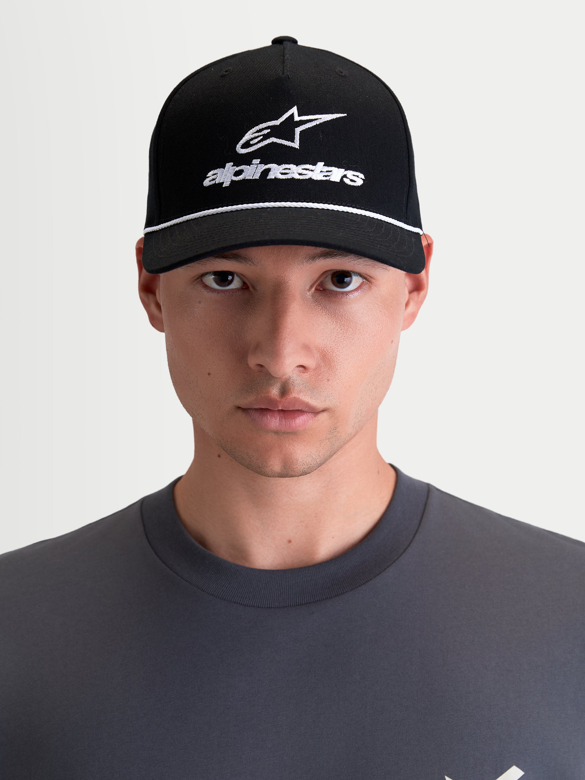 Alpinestars Combo Logo Snapback kasket, motorcykel sportswear kasket, unisex, sort og hvid, med buet skygge, struktureret krone og broderet Astars-logo, 100 % bomuldstwill, set forfra på model.