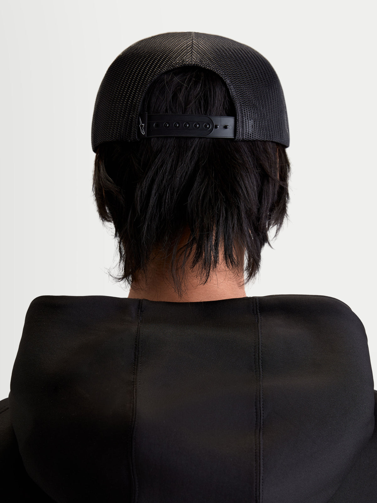 Alpinestars Gravel Trucker cap, sportswear snapback cap, sort, unisex, set bagfra på model med åndbar poly mesh-bagside og justerbar snapback-lukning.