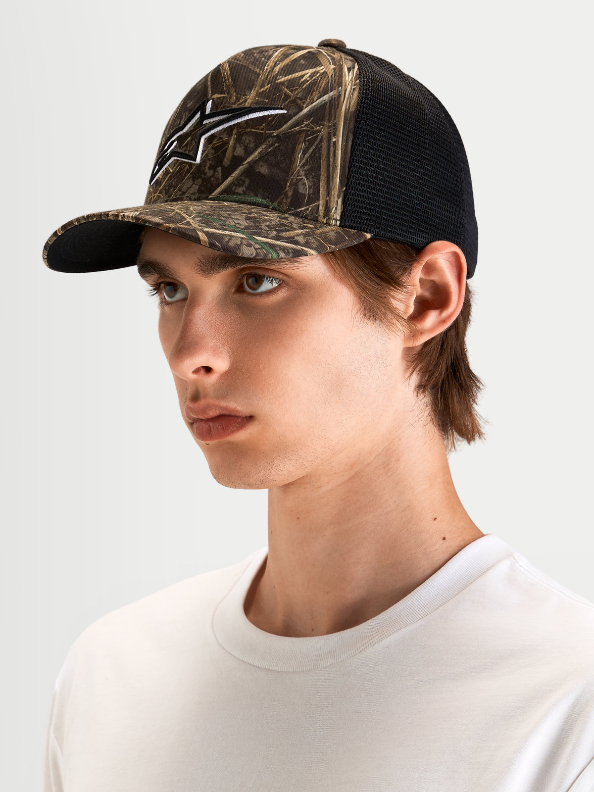 Alpinestars Thicket Realtree Trucker cap, mørkegrøn camo og sort, buet skygge, struktureret krone og 3D-broderet Astars-logo, båret af model