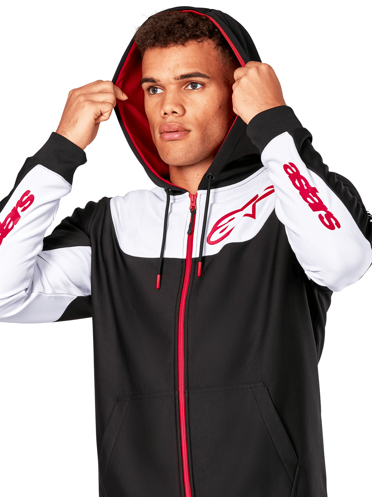 Alpinestars Sessions V3 hættetrøje, sort, hvid og rød, hættetrøje med lynlås foran båret af en mand med hætten oppe, med røde Alpinestars-logoer på brystet og ærmerne, afslappet motorsport-streetwear