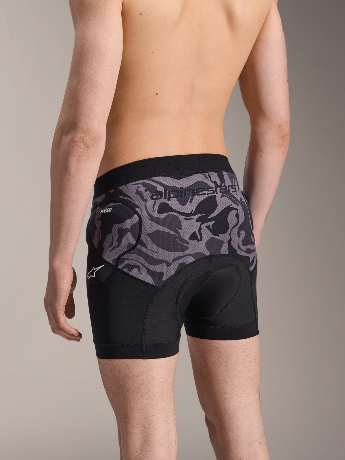 Alpinestars A-Motion Plasma Beskyttelsesboxershorts, Black Camo cykelbeskyttelsesshorts, set bagfra med ergonomisk design, Nucleon Plasma hoftebeskyttelse og chamois-pude, åndbart mesh-materiale med Alpinestars-logo på linningen