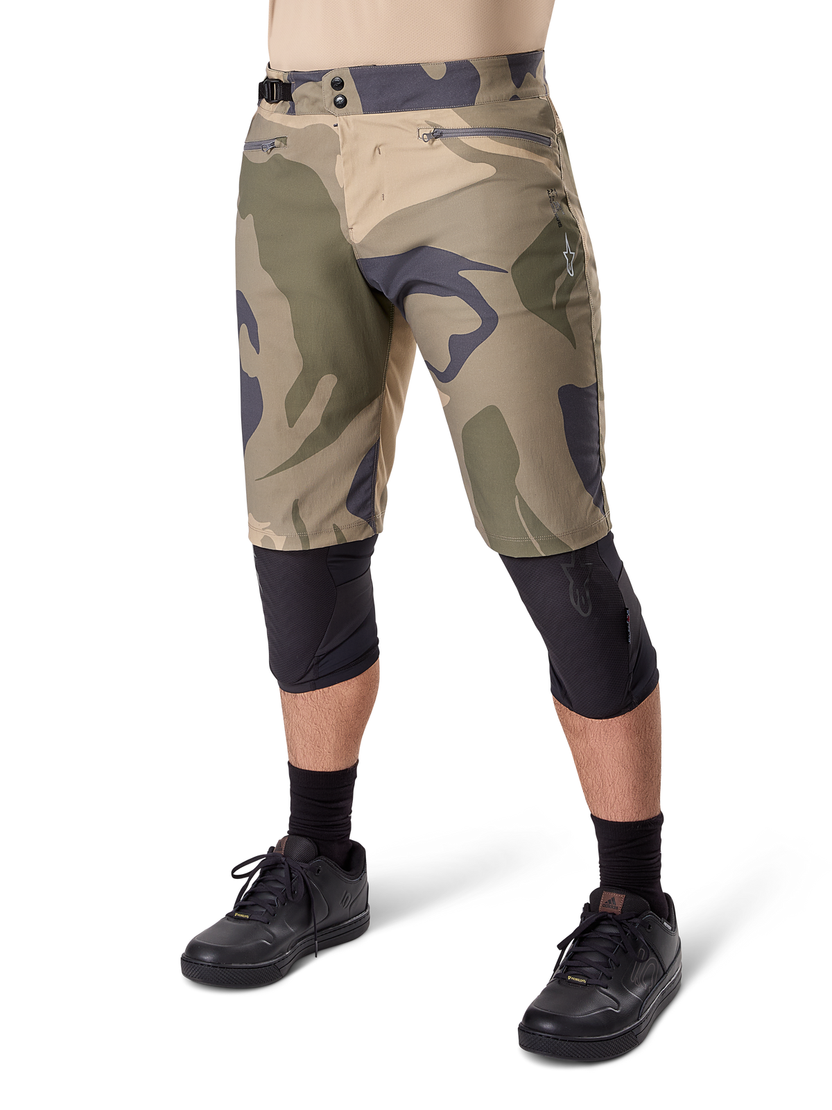 Alpinestars A-Dura Camo Liner Shorts, mountainbike-shorts, brunt camouflage-mønster, set forfra med lynlåslommer og taljejustering i siderne, båret med sorte knæbeskyttere og sorte cykelsko, slidstærkt udstyr til MTB