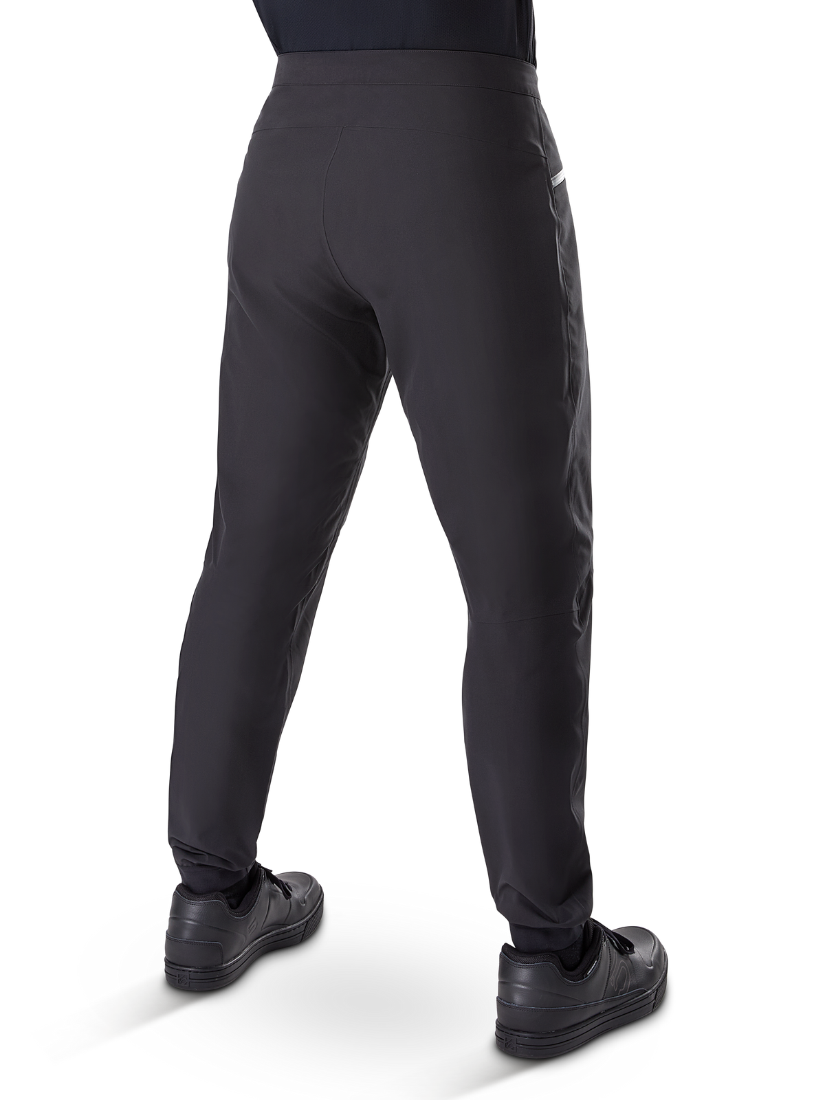 Alpinestars A-Dura vandtætte bukser, mountainbike-bukser, sort, set bagfra båret med sorte sko, med en holdbar 3-lags membran, almindelig pasform og elastiske manchetter til off-road cykling