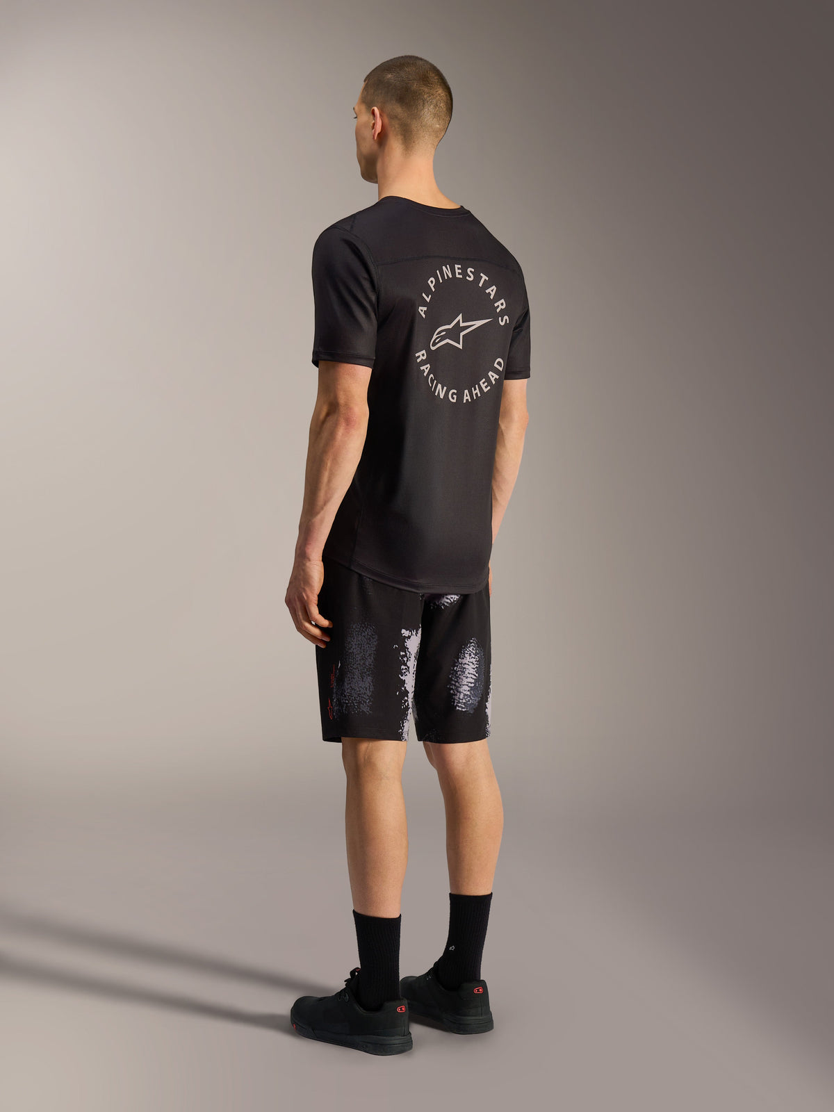 Alpinestars A-Dura Ride Shorts i Black Camo, holdbare MTB-shorts med 4-vejs stræk, vist bagfra på en model.