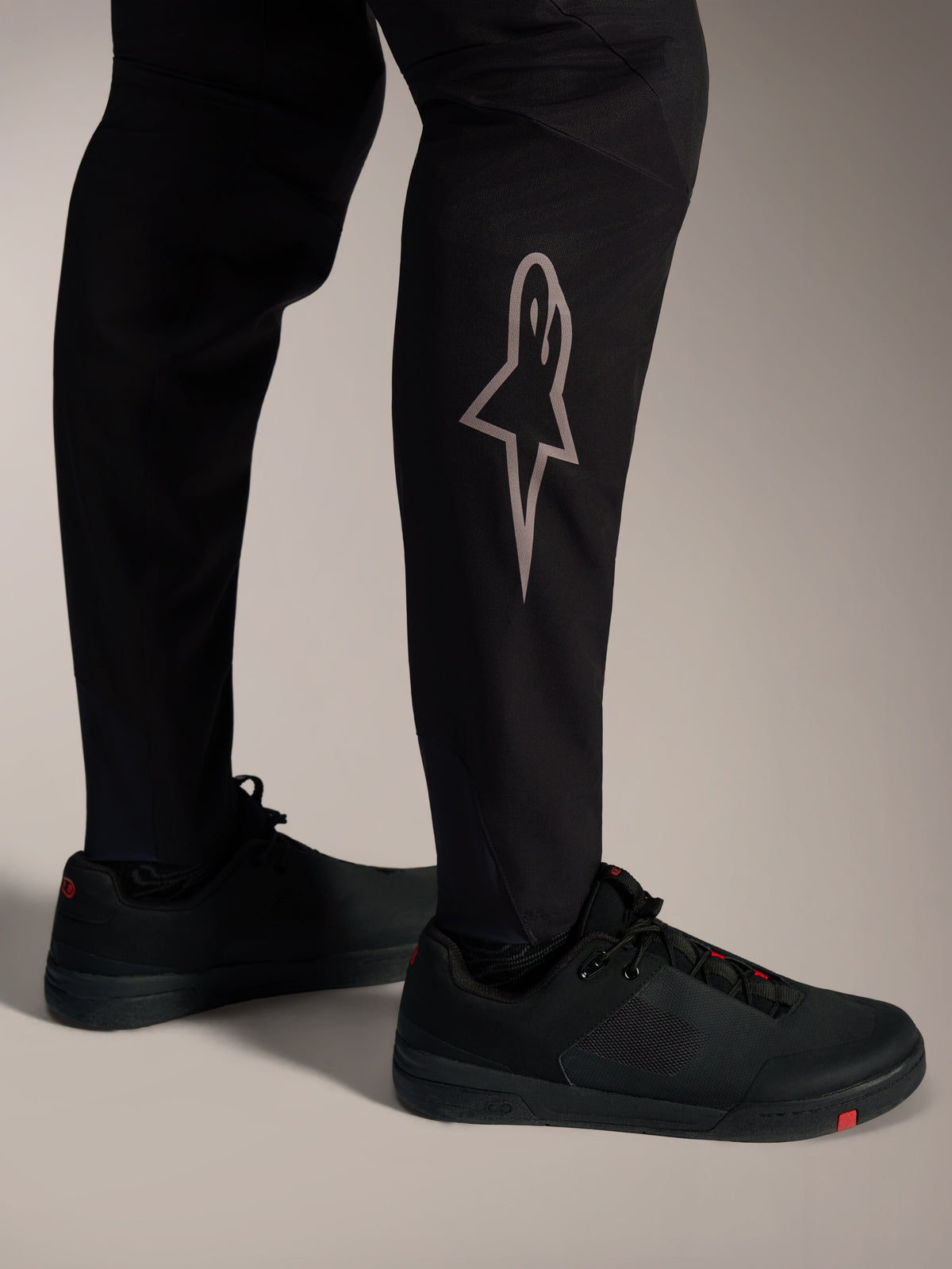 Sorte A-Supra Elite MTB-bukser med sølvfarvet Astars-logo på benet, designet til højtydende mountainbiking.