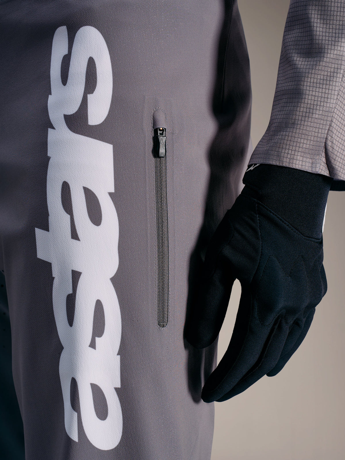 A-Supra Elite bukser i grå med hvidt Alpinestars-logo og lodret lynlåslomme, designet til MTB-racing.